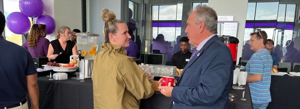 President Blake chatting with Tabitha Chapman over bagels and coffee at the Peyton Anderson Enrollment Center